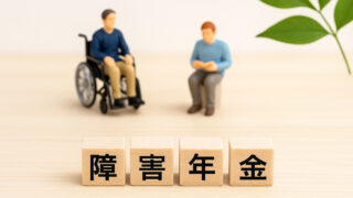 障害年金の４文字のウッドブロックとミニチュア人物