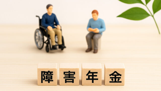 障害年金の４文字のウッドブロックとミニチュア人物